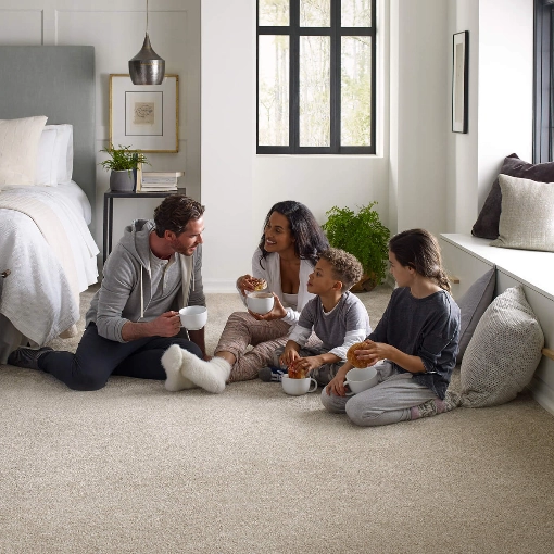 family sitting on a neutral carpet in living room